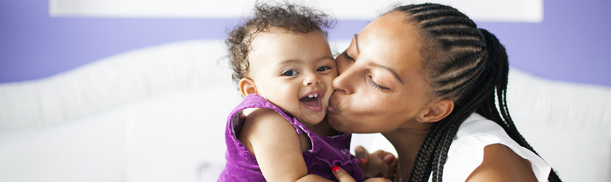 A mom kissing her baby on the cheek.