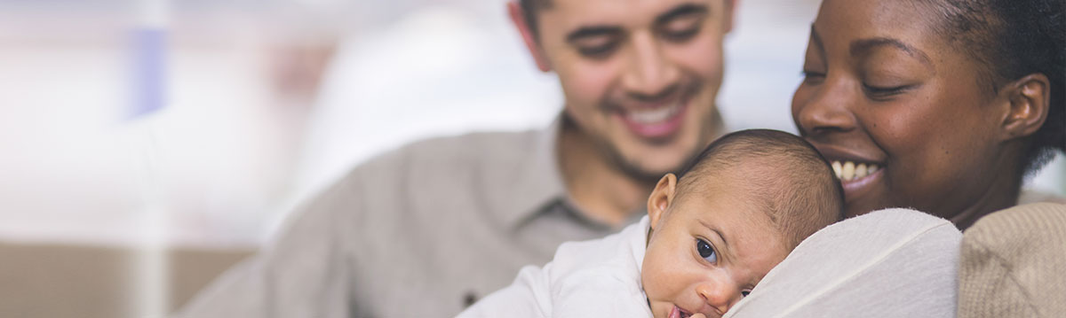 Smiling parents holding their baby.